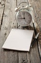 Open notebook with blank pages and pen with alarm clock Royalty Free Stock Photo