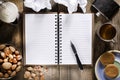 An open notebook with blank pages, pen on wood table.Cup of tea, hip flask,nuts and biscuits snack. Royalty Free Stock Photo