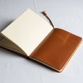 An open notebook with a brown leather cover rests on a white surface Royalty Free Stock Photo