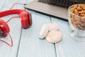 Open notebook with Cup of almonds, marshmallows and red headphones.