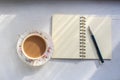 Open notebook and cup of tea on a sunny table top. Royalty Free Stock Photo