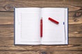 Open notebook diary with a pen for notes, on a wooden table. Royalty Free Stock Photo