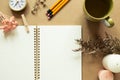 Open notebook with dry flowers, clock, pencils, cup of tea, candles on brown background Royalty Free Stock Photo
