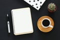 Open notebook with empty pages and other office supplies over black office desk table. Top view Royalty Free Stock Photo