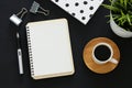 Open notebook with empty pages and other office supplies over black office desk table. Top view Royalty Free Stock Photo