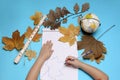 Open notebook, flute, globe, autumn leaves and hands of Caucasian girl