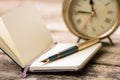 Open notebook with fountain pen and alarm clock Royalty Free Stock Photo