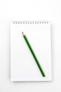 Open notebook with green Graphite pencil on white Royalty Free Stock Photo