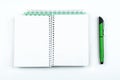 Open notebook and green pen isolated on a white background Royalty Free Stock Photo