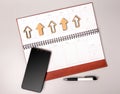 An open notebook in leather binding with a smartphone and pen on a gray background. Royalty Free Stock Photo