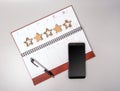 An open notebook in leather binding with a smartphone and pen on a gray background. Royalty Free Stock Photo