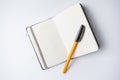 Open notebook with an orange ballpen on it Royalty Free Stock Photo