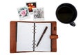 Open notebook with a pen, couple of polaroid pictures and a cup of tea Royalty Free Stock Photo