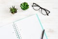 Open notebook, pen, glasses, mobile phone, a cup of coffee on a white wooden table, flat lay, top view. Office table desk, Royalty Free Stock Photo