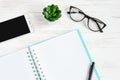 Open notebook, pen, glasses, mobile phone, a cup of coffee on a white wooden table, flat lay, top view. Office table desk, Royalty Free Stock Photo