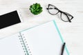 Open notebook, pen, glasses, mobile phone, a cup of coffee on a white wooden table, flat lay, top view Royalty Free Stock Photo