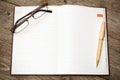 Open notebook with pen and glasses