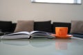 Open notebook with pen in the middle and orange cup of tea placed on coffee table Royalty Free Stock Photo