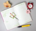 An open notebook, pen, orchid flower, scissors and an alarm clock reminiscent of time are on the table. Royalty Free Stock Photo