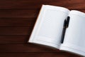 Open notebook with pen on wooden table. Top view with copy space Royalty Free Stock Photo