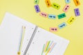 Open notebook, pencils and mathematical examples on yellow background. Back to school, fun learning of counting for kids
