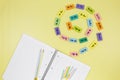 Open notebook, pencils and mathematical examples on yellow background. Back to school, fun learning of counting numbers for kids