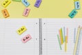 Open notebook, pencils and mathematical examples on yellow background. Back to school, fun learning of counting numbers for kids.