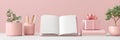 Open notebook with pink decor, accessories, and gift box on desk Royalty Free Stock Photo