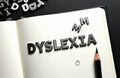 Open notebook shows dyslexia word from letters. Concept of learning disability. Cognitive reading problem for children. Royalty Free Stock Photo