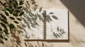 Open Notebook Sits on Beige Table With Spring Shadows, Inviting Fresh Ideas and New Beginnings During Daylight Hours Royalty Free Stock Photo