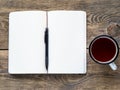 Open notebook on a spring with a white paper for notes and drawing near a pencil and a cup of tea. Royalty Free Stock Photo