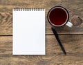 Open notebook on a spring with a white paper for notes and drawing near a pencil and a mug of tea. Royalty Free Stock Photo