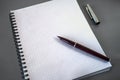 An open notebook on the table. A pen with a feather on a blank sheet of notebook. Pen cap next to it. Place for your text. Royalty Free Stock Photo