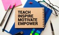 Open notebook with text Teach inspire motivate empower on wooden background Royalty Free Stock Photo