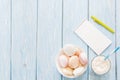 Open notebook, white mug with coffee, marshmallows.