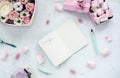 Open notebook on white table with flowers and marshmallow.Pastel colors.Flat lay Royalty Free Stock Photo