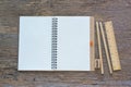 Open notebook on wooden background with pencils and ruler. Royalty Free Stock Photo