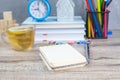 An open notebook on a wooden table, next to stand a silver pen and a cup of mint tea with lemon Royalty Free Stock Photo