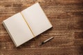 Open notebook with yellow blank pages and fountain pen on a wooden background Royalty Free Stock Photo