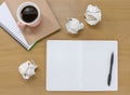 Open notebooks, paper and coffee on a wooden desk. Writer / artist flat lay with copy space