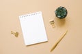 Open Notepad with a blank sheet of paper, ballpoint pen, succulent and paper clips on a beige background. Workplace of a Royalty Free Stock Photo