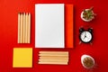 Open notepad with color pencils and flower pots on red background Royalty Free Stock Photo