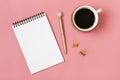 Open notepad, cup of coffee, golden pen moose on pink background spiral notebook on table Royalty Free Stock Photo