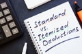 Open notepad and handwritten inscription. Standard vs Itemized deductions. Royalty Free Stock Photo