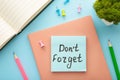 Open notepad and sticky notes with word don`t forget on blue background Royalty Free Stock Photo