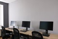 Open office interior. Modern workplaces with computers near light grey wall