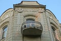 Open old black iron balcony on the brown wall of the house with a window Royalty Free Stock Photo