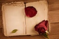 Open old book with blank pages for text and dry rose on wooden table Royalty Free Stock Photo