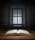 Open old book on a bookshelf background and the rays of light. Selective focus. Conceptual background on history, education, Royalty Free Stock Photo