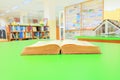 open old book interior library school on table green blur bookshelves background Royalty Free Stock Photo